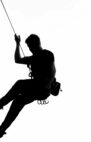 Black and white silhouette of a rock climber scaling a cliff in Pennadomo, Abruzzo, Italy.
